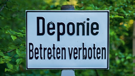 Das Bild zeigt ein Schild mit der Aufschrift "Deponie - Betreten verboten" in einem Wald. © picture alliance / Zoonar Foto: Bernd Brueggemann