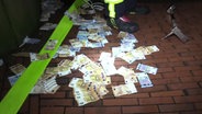 Geldscheine liegen in Harsefeld nach einer Automatensprengung auf der Straße. © TV Elbnews 