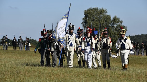 Eine Gruppe von Laienschauspielern stellt auf einem freien Gelände in historischen Kostümen die sogenannte Göhrdeschlacht vom 16. September 1813 nach. © Björn Vogt/dpa Foto: Björn Vogt