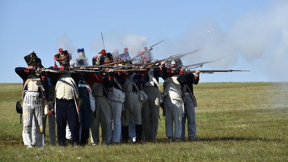 Mehrere Laienschauspielern stellen die sogenannte Göhrdeschlacht vom 16. September 1813 nach und feuern in einer militärischen Formation historische Gewehre ab. © Björn Vogt/dpa Foto: Björn Vogt