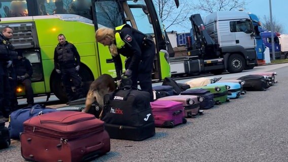 Polizisten untersuchen mit einem Hund Gepäckstücke im Rahmen einer Großkontrolle auf der A1. © Polizeiinspektion Rotenburg 