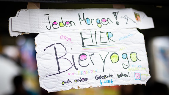 Die Aufschrift "Jeden Morgen - Hier - Bieryoga" ist auf dem Zeltplatz des Hurricane Festivals auf einem Schild zu lesen. © dpa-Bildfunk Foto: Moritz Frankenberg