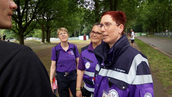 Drei ehrenamtliche Helfer des Deutschen Roten Kreuzes auf dem Hurricane-Festival. © NDR 