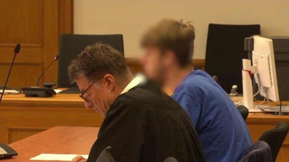 Ein 22-Jähriger (hinten) bei einem Prozess im Landgericht Lüneburg. Er soll als Intensivtäter unter anderem eine Tankstelle in Uelzen bewaffnet überfallen haben. © NDR 