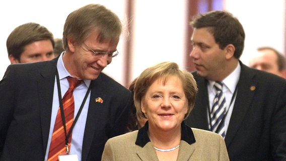 Bundeskanzlerin Angela Merkel (CDU) geht am Freitag (03.02.2012) in der Großen Halle des Volkes in Peking zusammen mit den mitreisenden Politikern Dietmar Bartsch (l, Die Linke) und Lars Klingbeil (r, SPD) zum Gesprächstermin mit dem Staatspräsidenten der Volksrepublik China. © picture alliance/dpa Foto: Kay Nietfeld