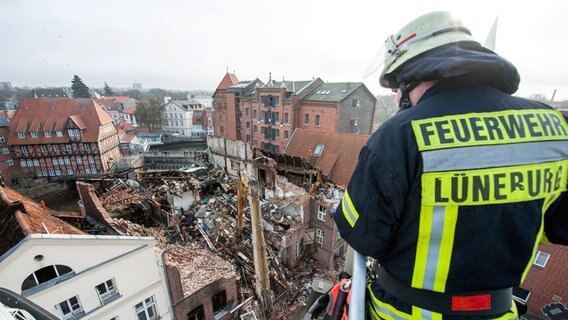 Feuerwehrmann schaut von oben auf eine Brandruine. © dpa Foto: Philipp Schulze