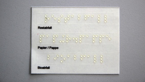 Auf einem Aufkleber steht in Brailleschrift "Restabfall, Papier/ Pappe, Bioabfall". © Landkreis Harburg 