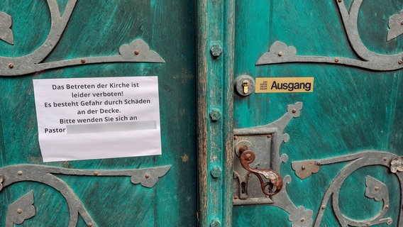 Am Eingang der Kirche St. Nicolai in Lüneburg hängt ein Zettel mit dem Text "Das Betreten der Kirche ist leider verboten! Es besteht Gefahr durch Schäden an der Decke! Bitte wenden SIe sich an Pastor...". © St. Nicolai Gemeinde 