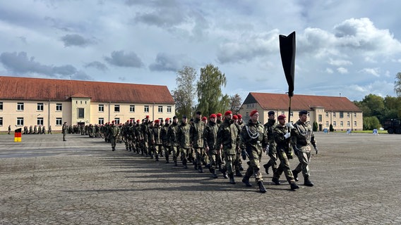 Bundeswehrsoldaten marschieren in Uniform über den Kasernenhof in Oerbke. © NDR Foto: Marie Schiller