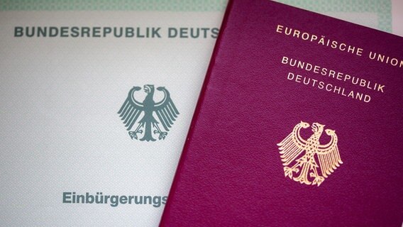 Eine Einbürgerungsurkunde der Bundesrepublik Deutschland (li) und ein deutscher Reisepass liegen nebeneinander. © Fernando Gutierrez-Juarez/dpa Foto: Fernando Gutierrez-Juarez/dpa