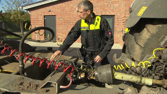 Ein Polizist überprüft die Verbindung eines Sattelschleppers. © NDR 