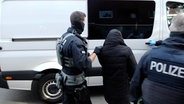 Ein Mann wird von maskierten Polizisten abgeführt © NEWS5 