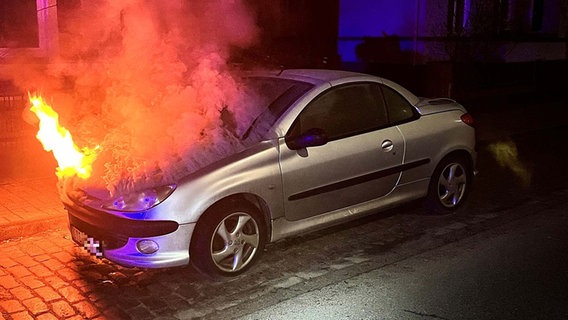 Ein Auto mit brennender Motorhaube vor einem Gebäude © Polizeiinspektion Stade 