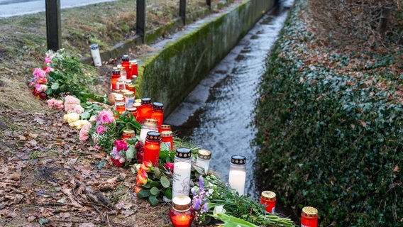 Blumen und Kerzen stehen an einem Graben an einer Straße an der ein 17-Jähriger gestorben ist. © JOTO Foto: Tobias Johannig