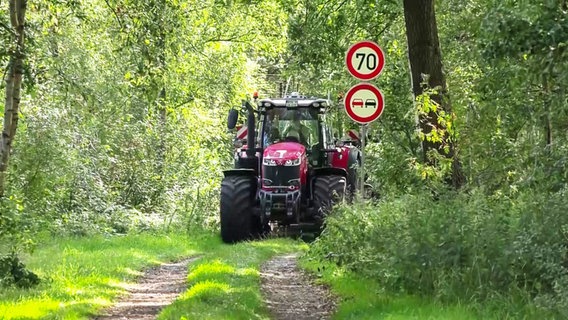 Ein Traktor fährt auf einem schmalen Wirtschaftsweg im Landkreis Rotenburg, daneben stehen Schilder mit einem Tempolimit von 70 km/h und einem Überholverbot. © TV Elbnews 