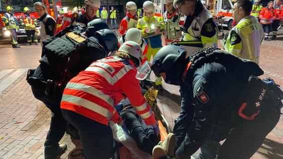 Rettungskräfte und Spezialeinsatzkräfte der Polizei versorgen eine Person bei einer Großübung in Uelzen. © NDR Foto: Eike Müller