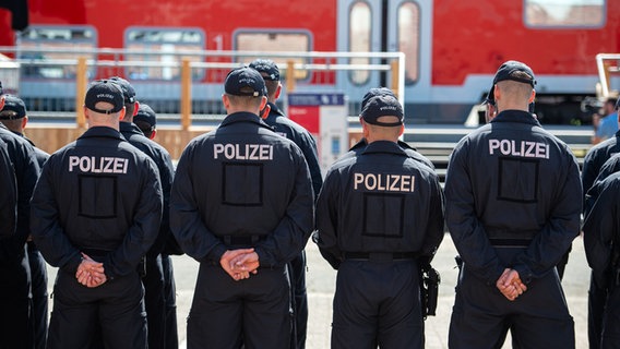 Mehrere Polizisten stehen in einer Reihe mit verschränkten Armen, im Hintergrund ist ein Zug zu sehen. © dpa - Bildfunk Foto: Philipp Schulze