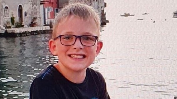 Das Bild zeigt einen 13-jährigen Jungen mit Brille, der auf einer Mauer am Wasser sitzt. © privat Foto: privat