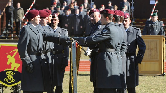 Mit der Hand auf der Bundesflagge legen Rekruten in der Panzertruppenschule in Munster das letzte Gelöbnis von Wehrpflichtigen ab. © dpa - Bildfunk Foto: Holger Hollemann