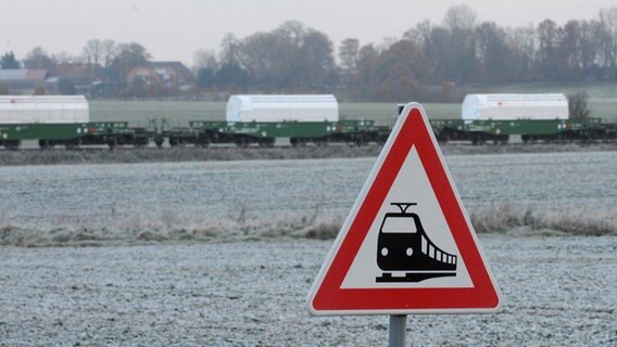 Der Castor-Transport fährt durch Oldendorf. Im Vordergrund ist ein Verkehrszeichen für Bahnübergänge zu sehen. © dpa-Bildfunk Foto: Marcus Brandt