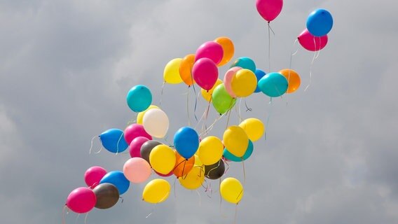 Bunte Luftballons steigen in den Himmel auf. © picture alliance Foto: Axel Kammerer