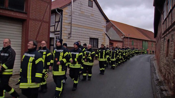 Feuerwehrleute nehmen in Warle an einer Gedenkveranstaltung für einen getöteten Jungen teil. © NonstopNews 