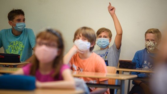 Schüler sitzen mit Mund-Nasen-Bedeckungen im Unterricht. © picture alliance Foto: Gregor Fischer