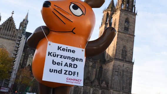 Die von Aktivisten von "Campact e.V." in Köln entführte Maus aus der «Sendung mit der Maus» steht vor dem Magdeburger Dom auf dem Domplatz, an dem sich auch der Landtag von Sachsen-Anhalt befindet. © Simon Kremer/dpa Foto: Simon Kremer