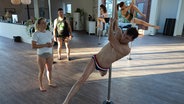 Ein Mann tanzt an einer Pole Dance-Stange. © NDR 