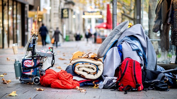 Die Habseligkeiten eines obdachlosen Menschen liegen auf einem Bürgersteig in der Innenstadt. © dpa-Bildfunk Foto: Hauke-Christian Dittrich/dpa