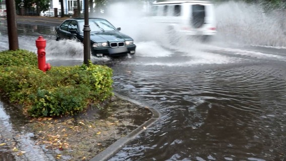 Autos fahren über eine überflutete Straße. © Nord-West-Media TV 