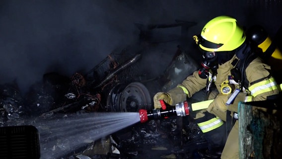 Feuerwehr bei Löscharbeiten: In Achim ist ein Mann aus einem brennenden Wohnwagen gezogen worden. © TNN 