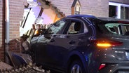 Ein Auto steht nach einem Unfall in Apen in einer Hauswand. © NonstopNews 