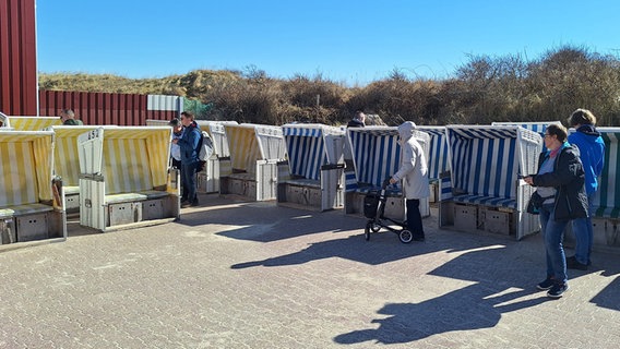 Interessierte besichtigen Strandkörbe bei der ersten Standkorbauktion auf Baltrum. © dpa Foto: Kai Moorschlatt