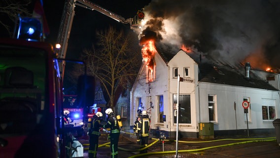 Einsatzkräfte der Feuerwehr löschen einen Hausbrand in Bunde. © dpa-Bildfunk Foto: Lars Penning