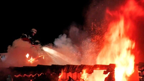 Ein Feuerwehrmann löscht ein brennendes Haus in Bunde. © NonstopNews 