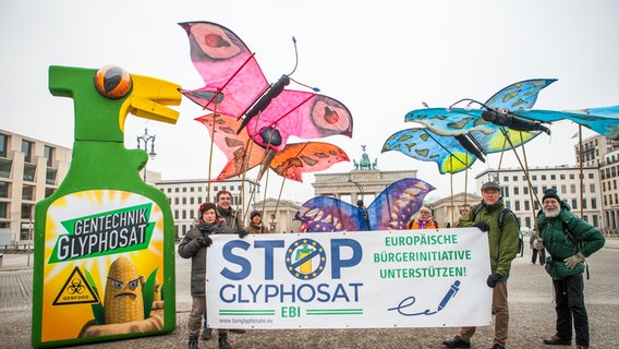 Eine Demonstration gegen Glyphosat mit gebastelten Utensilien wie einer übergroßen Sprühflasche und Schmetterlingen. © Campact 