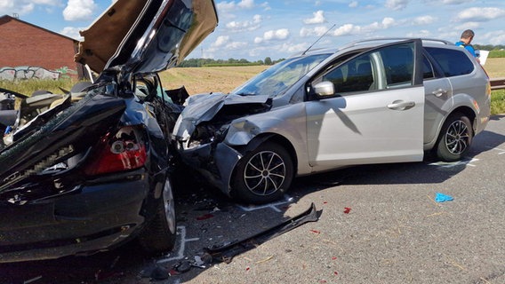 Nach einem Unfall in Cloppenburg stehen zwei stark zerstörte Autos auf einer Straße. © Nord-West-Media/dpa 