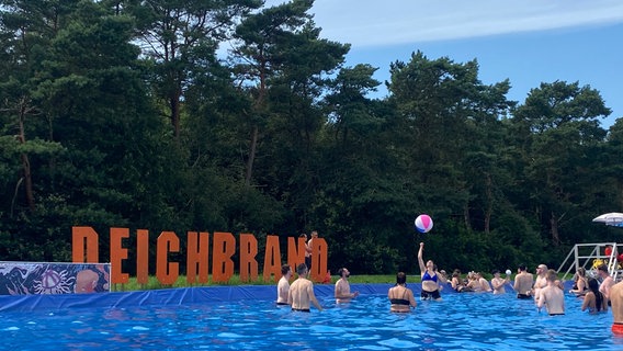 Besucher des Deichbrand Festivals spielen Wasserball in einem Swimmingpool. © NDR Foto: Peter Becker