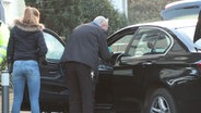 Kripobeamte untersuchen einen BMW. © NonstopNews 