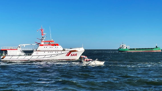 Ein Schiff der DGzRS an einem Segelboot, das mit einem Frachter kollidiert ist. © Die Seenotretter – DGzRS 