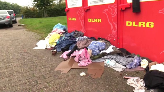 Kleidung vor überfüllten Altkleidercontainern der DLRG. © TV Elbnews 