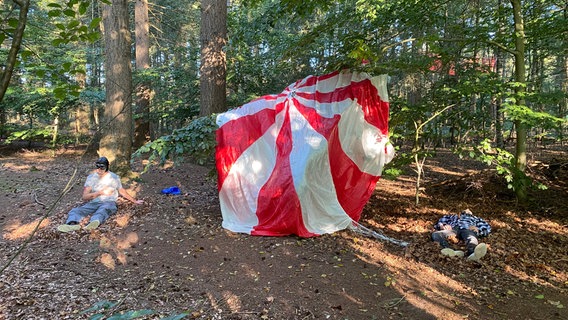 Zwei Männer stellen für einen Wettbewerb des DRK einen vom Baum aufgespiessten Fallschirmspringer  und einen am Kopf schwer verletzten Mann dar. © NDR Foto: Peter Becker