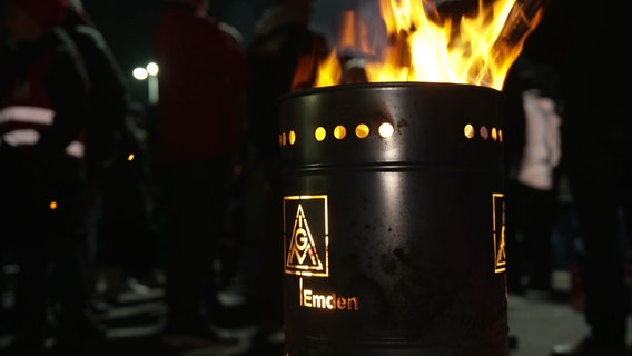 In einer Tonne mit der Aufschrift "IGM Emden" brennt ein Feuer. © NDR 