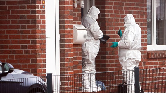 Beamte der Spurensicherung stehen im Emder Stadtteil Larrelt vor einem Einfamilienhaus. © dpa-Bildfunk Foto: Jens Doden