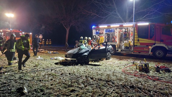 Einsatzkräfte stehen nach einem Unfall neben einem schwer beschädigten Pkw auf einem Feld. © Freiwillige Feuerwehr Samtgemeinde Barnstorf 