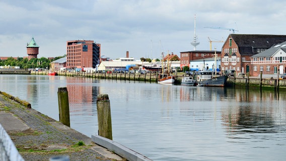 Das Becken des Alten Fischereihafen in Cuxhaven mit Gebäuden am Ufer die sich im Wasser spiegeln. © picture alliance Foto: Michael Narten