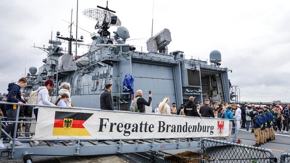 Angehörige von Besatzungsmitgliedern gehen bei der Rückkehr der Fregatte "Brandenburg" (F215) aus dem Mittelmeer nach dem Anlegen an Bord. © dpa Foto: Focke Strangmann