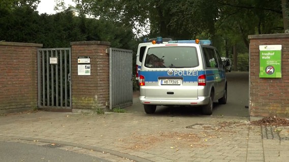 Ein Wagen der Polizei an einem Friedhofseingang in Bremen, auf dem eine blutüberströmte Leiche entdeckt wurde. © NonstopNews 