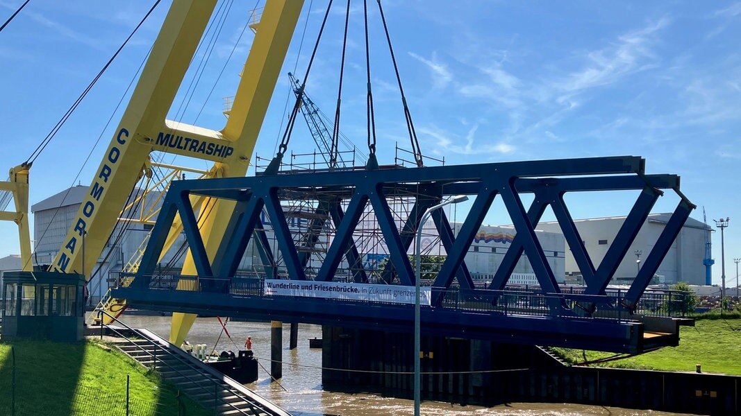 Ein Teil einer Drehbrücke wird in Weener mit einem Schwimmkran gesetzt.